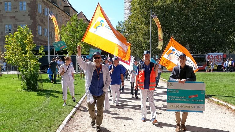 Sie halten die Fahne für die OSK hoch: 29 Mitarbeiter aus Ravensburg und Wangen haben am Mittwoch am bundesweiten Protesttag der Kliniken in Stuttgart für mehr finanzielle Unterstützung für Krankenhäuser protestiert.