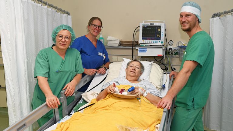Freuen sich, ihrer Patientin mit dem Wassereis ein Lächeln ins Gesicht zu zaubern (von links): Rosi Wildenstein, Pflegefachkraft für Anästhesie- und Intensivpflege, Dr. Agnes Schön-Morgenweck, Fachärztin für Anästhesie, und Oberarzt Dr. Jonas Meister.